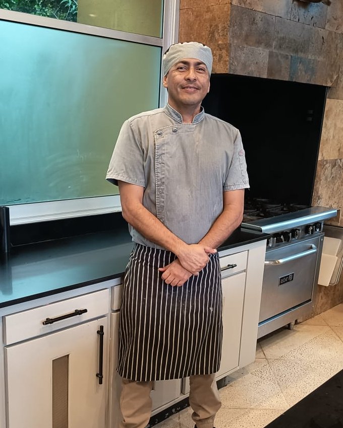 Jorge Jiménez Lara in the kitchen, wearing a chef jacket and apron